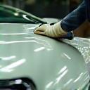 Technician meticulously polishing a car exterior